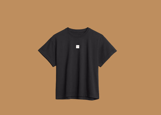 Black t-shirt with a small white logo on a white background